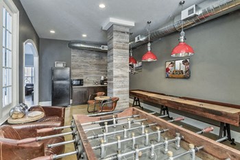 Resident gaming lounge with a fooseball table and shuffleboard table at The Retreat at the Park in Burlington, NC
